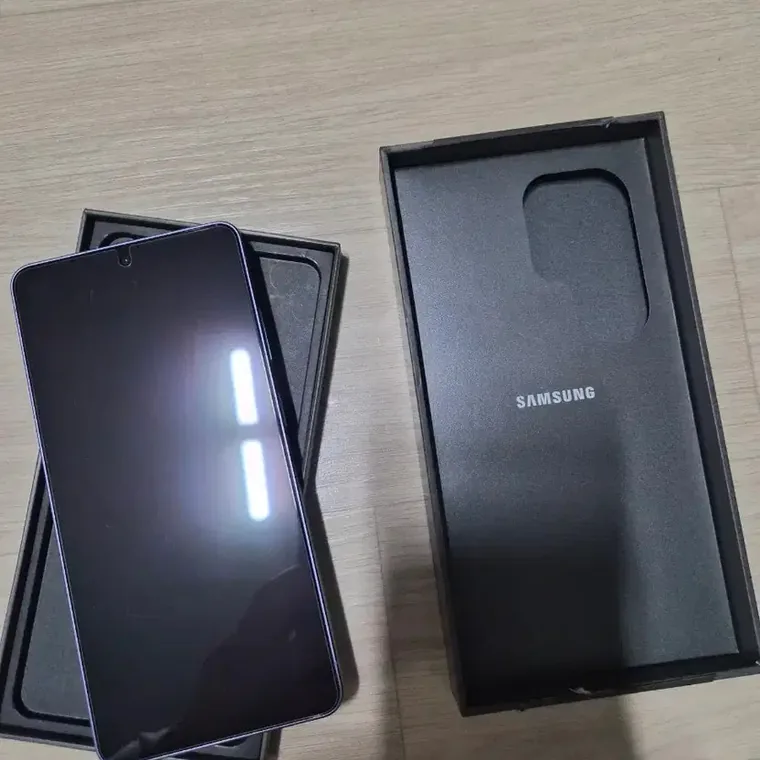 Galaxy S26 Ultra allumé sur son plateau, le couvercle de la boîte à côté